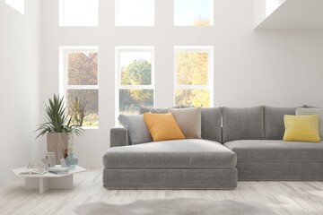 Stylish room in white color with sofa and autumn landscape in window. Scandinavian interior design. 3D illustration