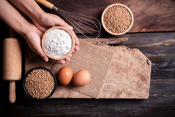 Kitchen utensil for bakery cooking and food ingredients (wheat grain, flour and egg) on wooden background, Table top view