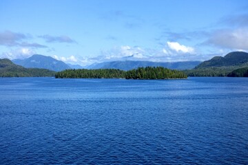 Majestic views of the forested mountains and beautiful blue ocean along the british columbia coast along the BC ferries inside passage route, on a beautiful sunny day