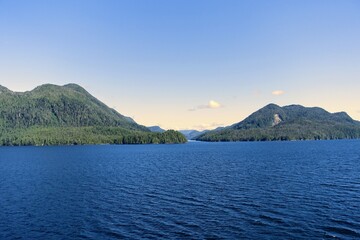 Majestic views of the forested mountains and beautiful blue ocean along the british columbia coast along the BC ferries inside passage route, on a beautiful sunny day