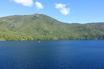 Obraz premium Majestic views of the forested mountains and beautiful blue ocean along the british columbia coast along the BC ferries inside passage route, on a beautiful sunny day