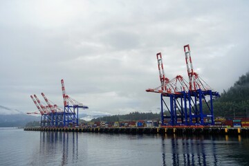 Container cranes loading shipping containers at the port in Prince Rupert, British Columbia, Canada.