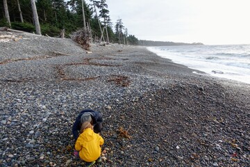 A mother and daughter exploring the shores for agates on agate beach and North Beach, in Naikoon Provincial Park, Haida Gwaii, British Columbia, Canada
