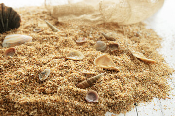 Sand and seashells on white wooden background