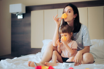 Mother and Daughter Having a Tea Pajama Party in Bed