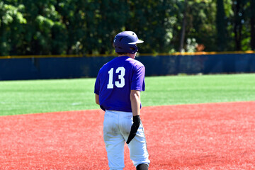 A baseball player on third base wearing number 13