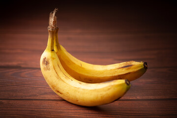 Close-up of two ripe banana (Musa sp) fruits over the wooden background.