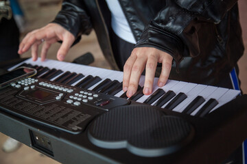 A man plays a synthesizer in close-up. Hands playing the synthesizer close-up.