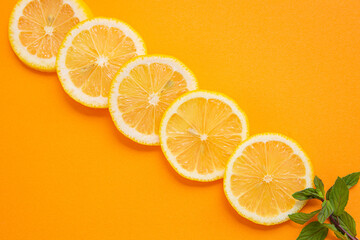 sliced lemons on orange background
