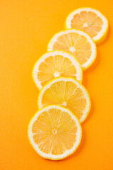 sliced lemons on orange background