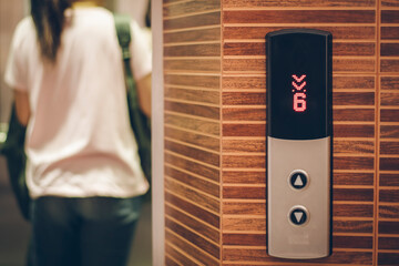 The screen of the elevator going up shows the number 6. and is scrolling down and saw a woman in the elevator © Palakorn Jaiman