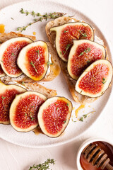 Breakfast with sweet bruschettas with figs and honey on a white plate
