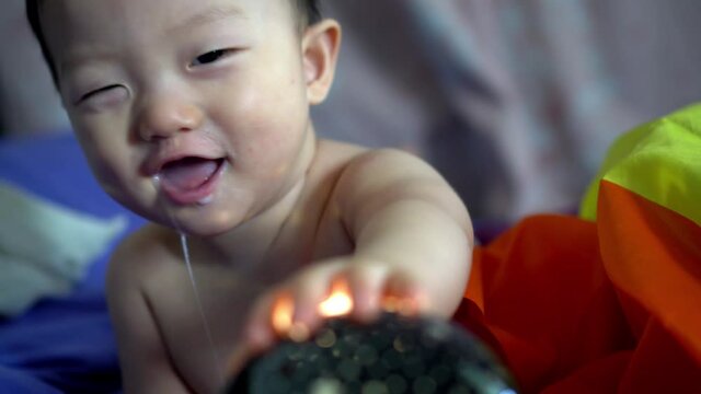 Drooling baby boy play with the equipment of illumination light