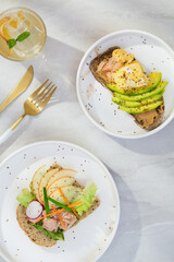 Avocado and apple on toast with fresh thyme, lemon, and black sesame seeds and Lemon juice is good for health. Top view