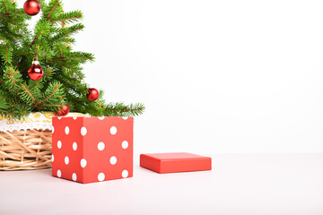 Close-up of a Christmas and New Year composition with a branch of a Christmas tree and a red gift box in white polka dots . A place to copy.