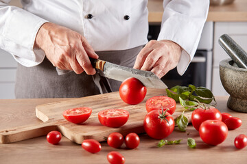 Crop cook cutting ripe tomatoes