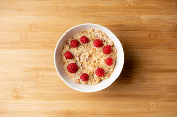 Oatmeal porridge with sweet raspberries. Selective focus.