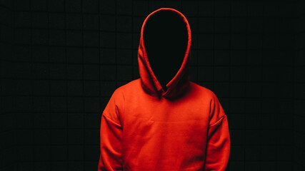 Anonymous and faceless man under orange  hoodie