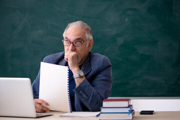 Old male teacher in the classroom