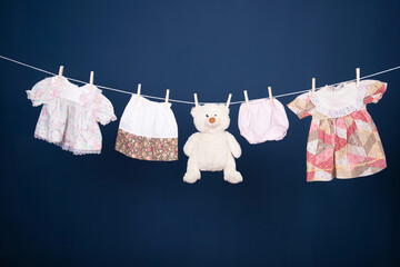 Baby clothes hanging on the rope on blue background.