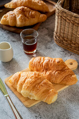 Delicious homemade butter croissants on wooden plate for breakfast