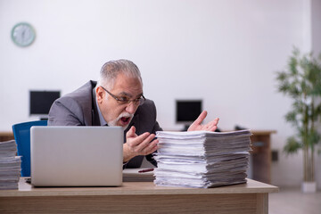 Old male employee unhappy with excessive work in the office