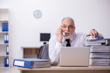 Old male employee unhappy with excessive work in the office