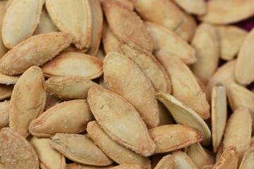 Whole roasted salted pumpkin seeds, macro shot