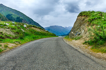 Fototapeta premium Asphalt road and green mountain natural landscape in Xinjiang,China.
