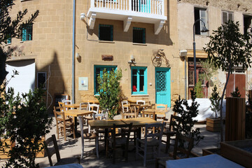 An empty cafe and a house with turquoise Windows.  Cyprus.