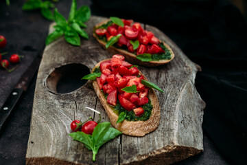 Bruschetta with pesto and tomatoes on a dark background