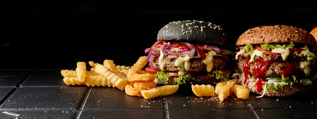 Burgers and fries on dark background