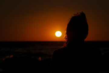 Woman on the beach at sunrise
