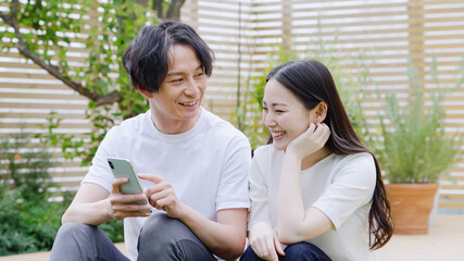 スマホを見る若い夫婦・カップル