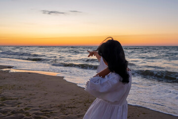 Woman on the beach at sunrise