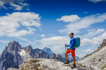 Man with backpack hiking in Dolomites mountains. Travel, lifestyle, adventure, mountaineering, sport concept. Tre cime di lavaredo national park, south tyrol