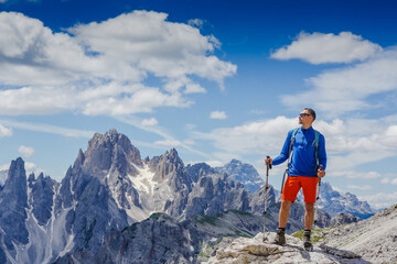 Man with backpack hiking in Dolomites mountains. Travel, lifestyle, adventure, mountaineering, sport concept. Tre cime di lavaredo national park, south tyrol