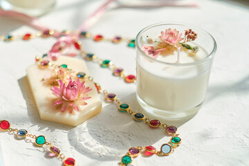 Handmade sachets and homemade candles with Pink and red dried flowers. Flat lay on grey textured table