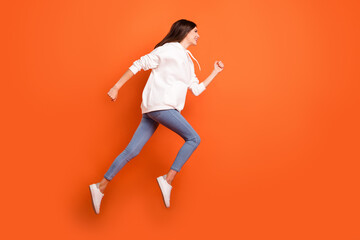 Fototapeta na wymiar Full length body size profile side view of pretty motivated cheerful girl jumping running isolated bright orange color background