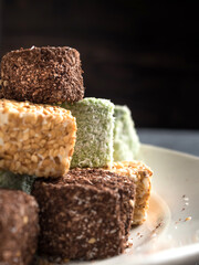 Close-up Traditional multi-colored oriental dessert Turkish delight on a white plate. Side view. Vertical