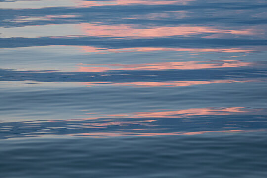 blue and pink reflection in the water, metallic blue water, abstract background