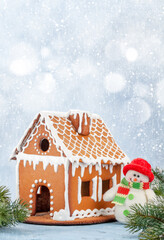Christmas greeting card with gingerbread house and snowman