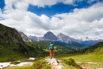 Man traveler with breathtaking landscape of Dolomites Mounatains in summer, Italy. Travel Lifestyle...