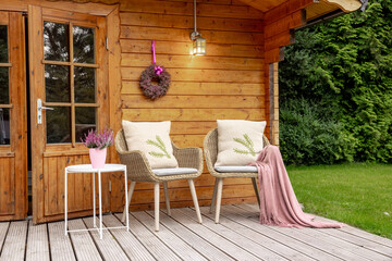 Two chairs in the garden with a pink blanket and heather. Heather as decoration. Chairs to relax and enjoy the time in the garden. Wooden garden shed 