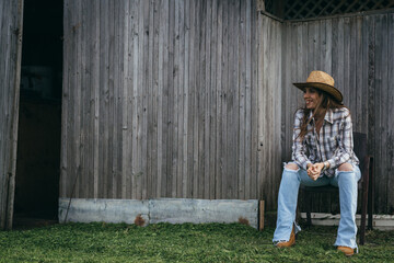 woman farmer sitting by the wooden barn © cherryandbees