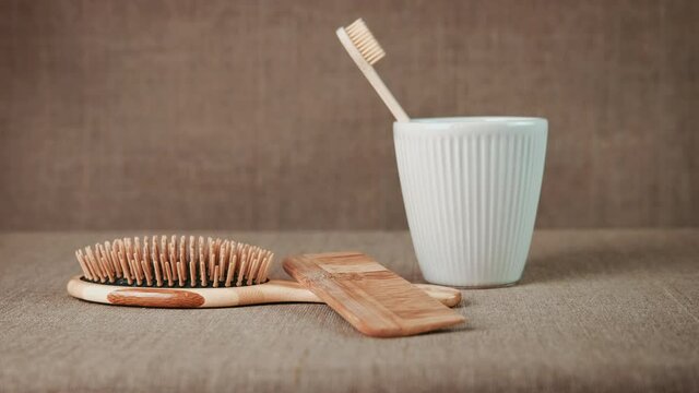Life without plastic. In a ceramic cup, a bamboo toothbrush, with wooden combs on a linen cloth. Sustainable friendly lifestyle concept.
