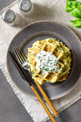 Homemade zucchini waffles in a plate on a culinary background top view
