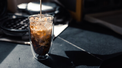 Close-up of iced coffee served on black table at cafe​