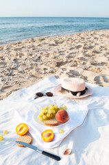 Summer picnic on the beach by the sea at a sunrise. Picnic with fresh ripe summer fruits.