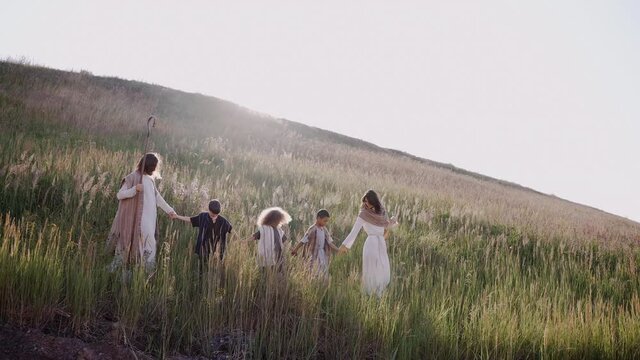 Jesus with the children and Mary is walking up the hill, the ears are swaying, the sun is shining. High quality 4k footage